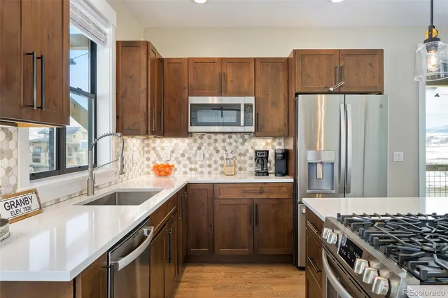 a kitchen with stainless steel appliances granite countertop a sink stove and refrigerator