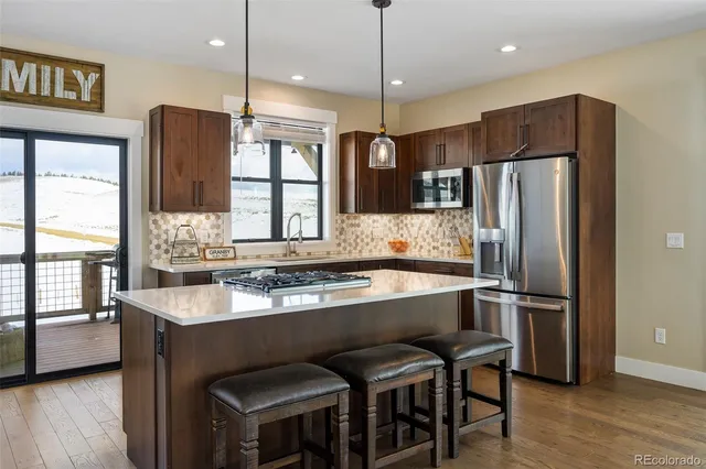 a kitchen with stainless steel appliances granite countertop a sink refrigerator and microwave