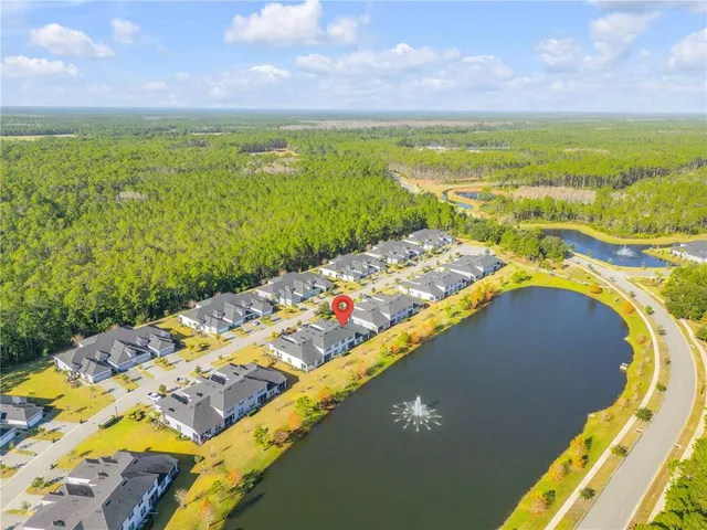 an aerial view of residential houses with outdoor space and a lake view