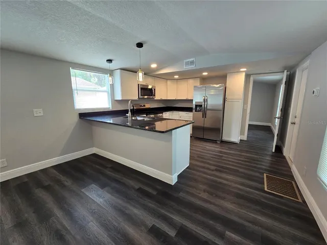 a kitchen with granite countertop a stove and a refrigerator