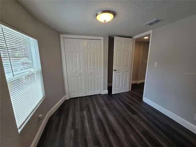 a view of a room with wooden floor and a window