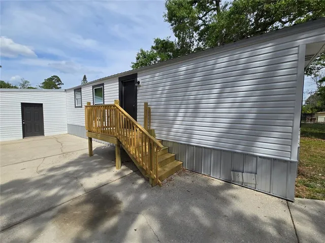 a view of a house with a yard and stairs