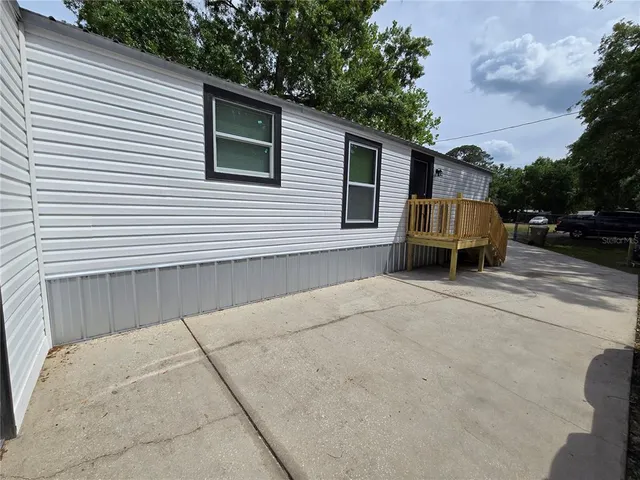 a backyard of a house with barbeque oven and trees