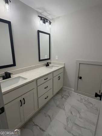 a bathroom with a double vanity sink and mirror
