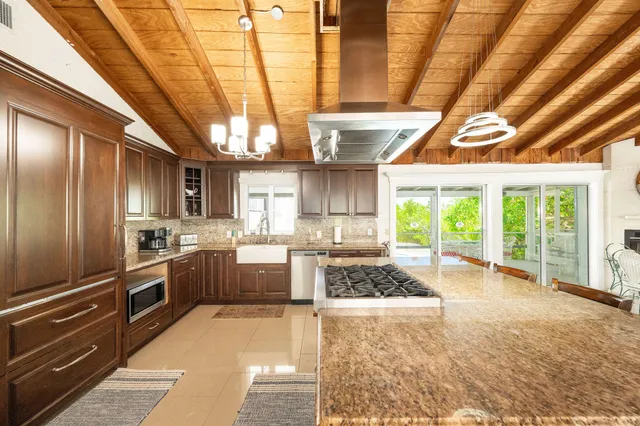 a view of patio with table and chairs under an umbrella with a small yard