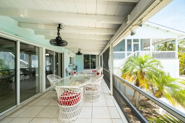 a view of white house with a yard and potted plants