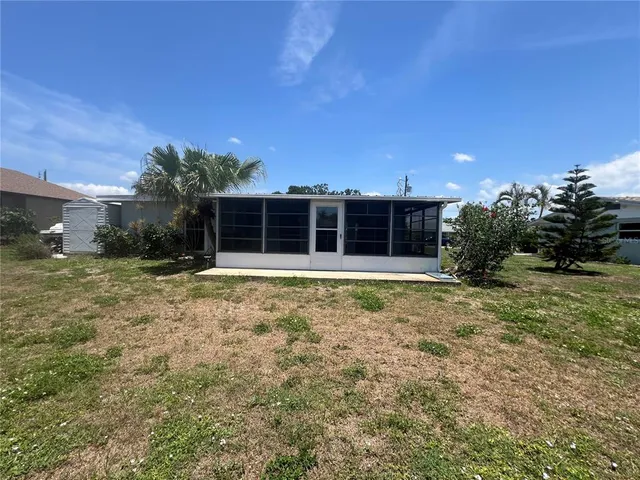 a view of a house with a yard and potted plants