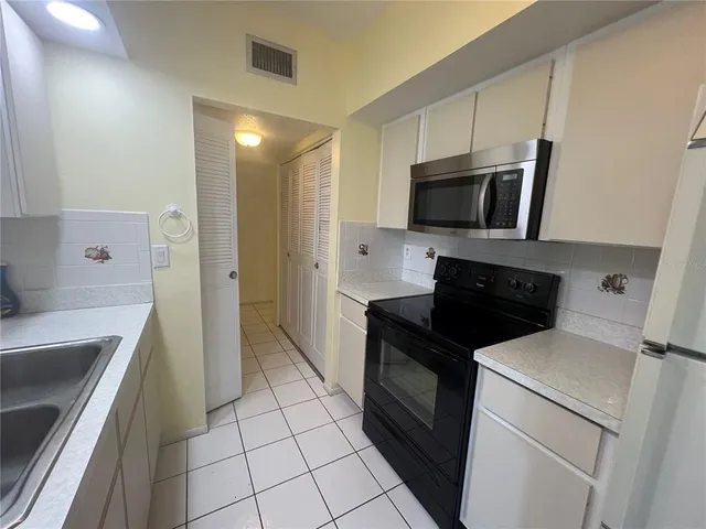 a kitchen with a sink and steel appliances