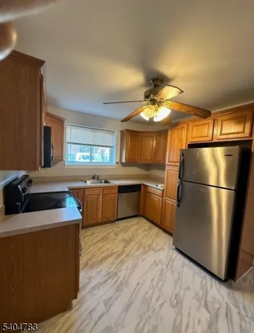 a kitchen with stainless steel appliances granite countertop a refrigerator a sink a stove a microwave and island