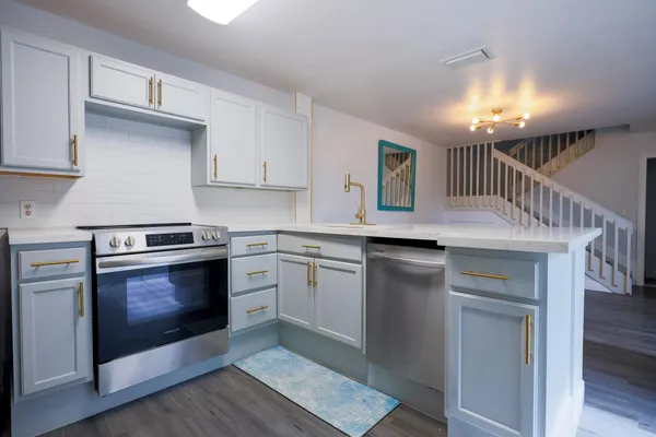 a kitchen with cabinets appliances and a wooden floor