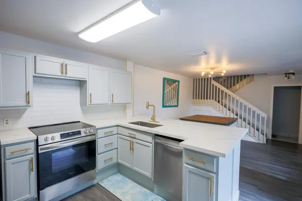 a kitchen with granite countertop a white stove top oven and cabinets