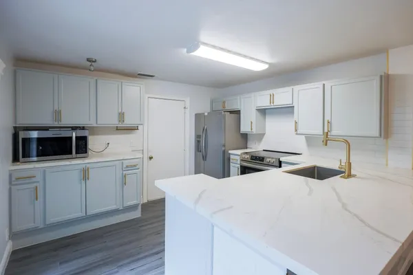 a kitchen with stainless steel appliances a refrigerator sink and cabinets