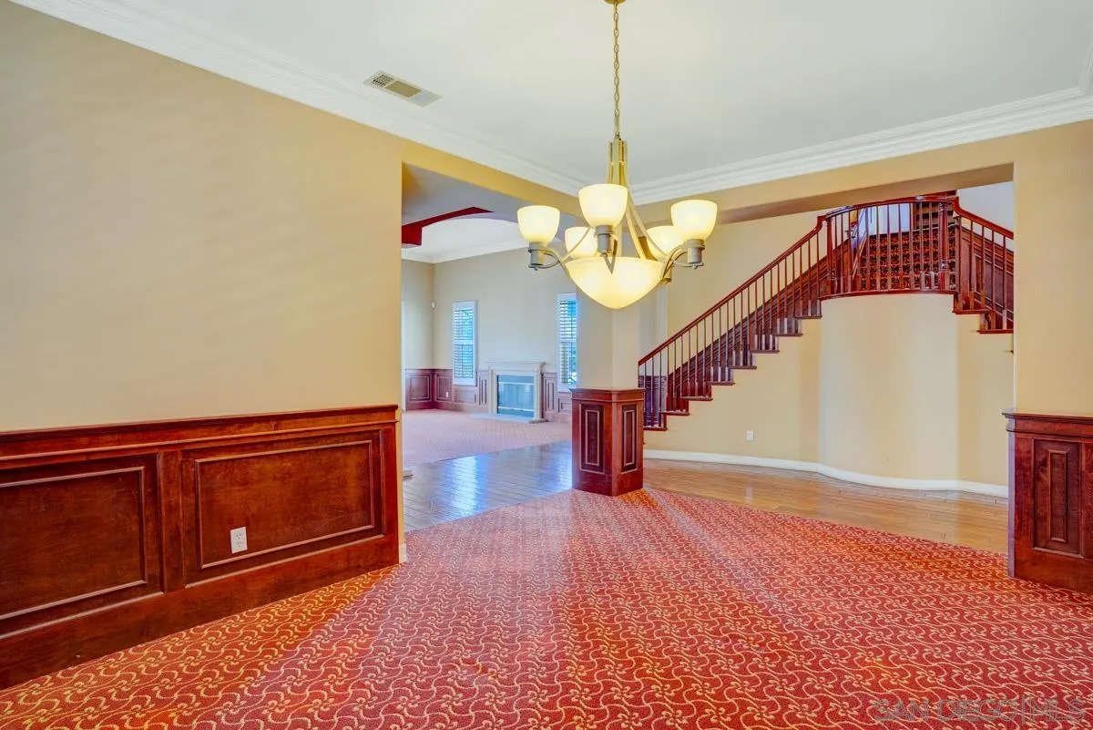961 Red Granite Road Chula Vista, CA 91913 - Photo 5 of 27 a view of a hallway with a dining table and chandelier