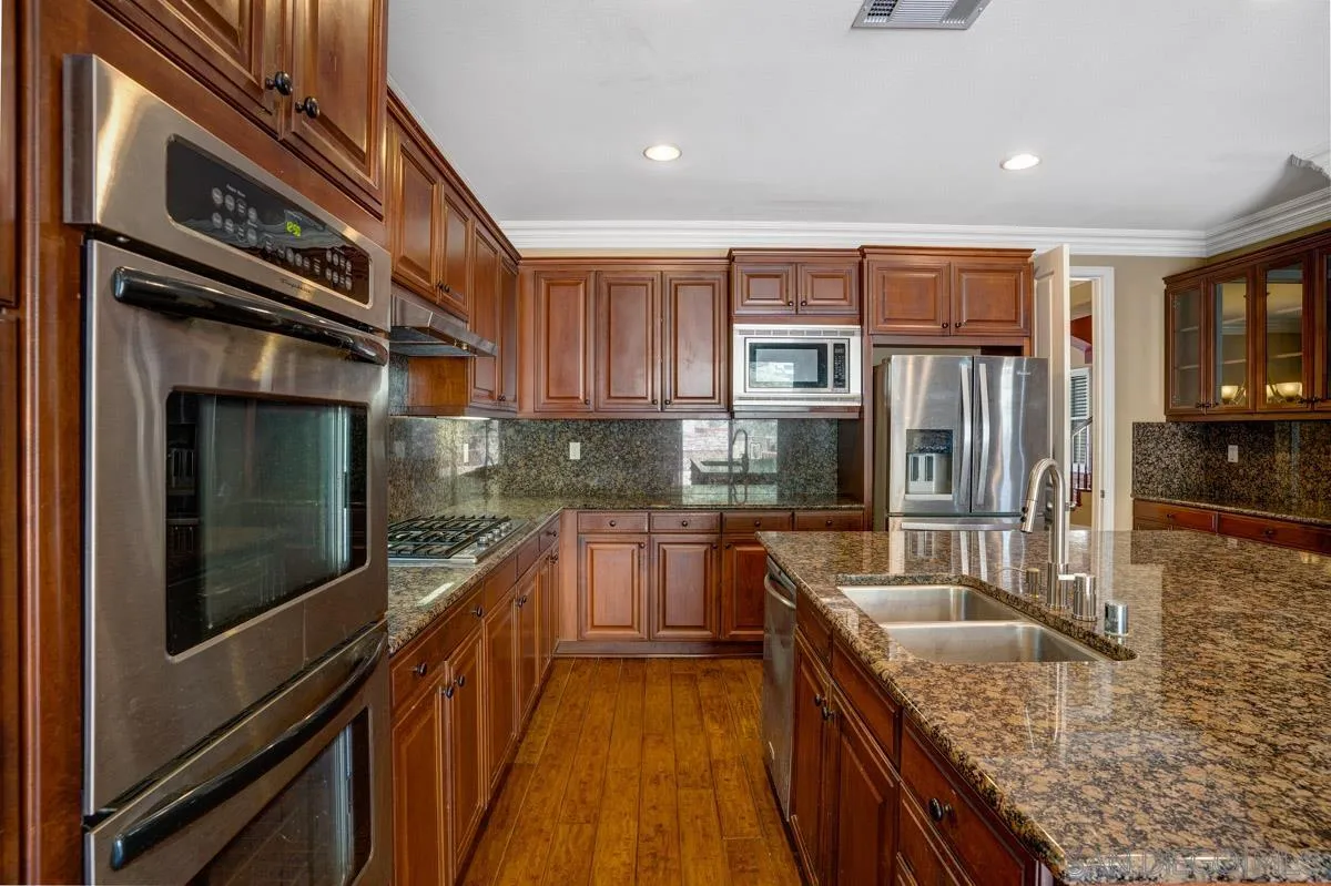 961 Red Granite Road Chula Vista, CA 91913 - Photo 9 of 27 a kitchen with stainless steel appliances granite countertop a stove a sink and a refrigerator