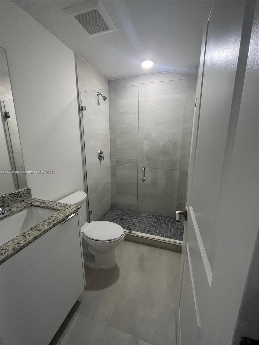 535 Southwest 5th Street, Unit 5 Miami, FL 33130 - Photo 14 of 19 a bathroom with a granite countertop sink toilet and shower