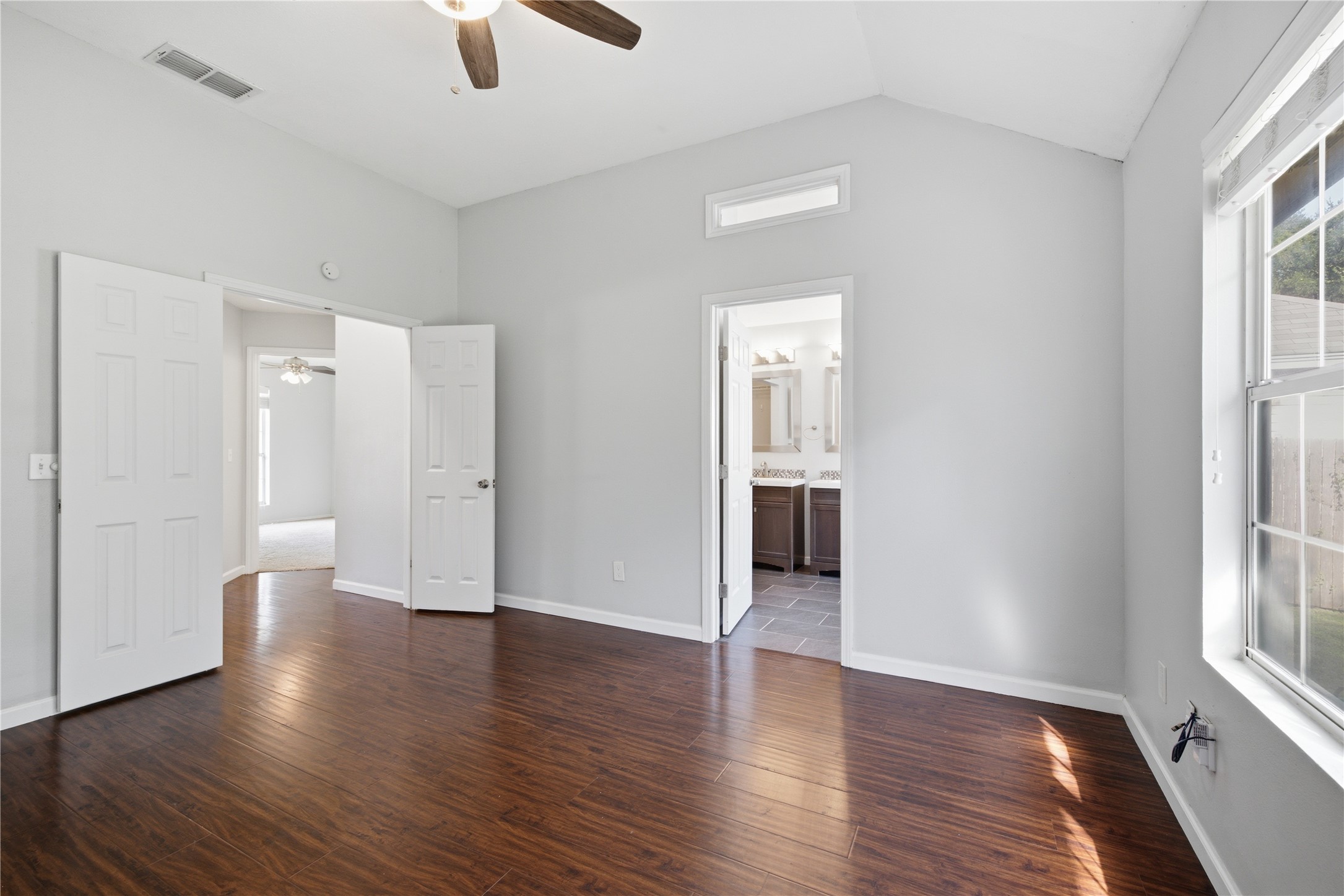 2922 Wickersham Lane Austin, TX 78741 - Photo 5 of 26 an empty room with wooden floor and windows