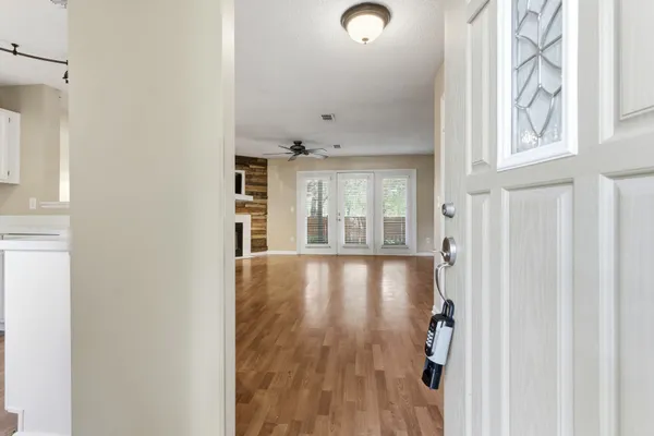 a view of an empty room with wooden floor and a fireplace