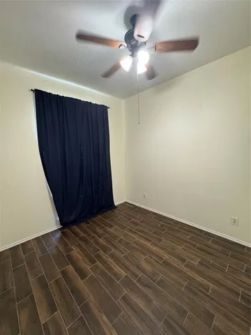 a view of a room with wooden floor and fan