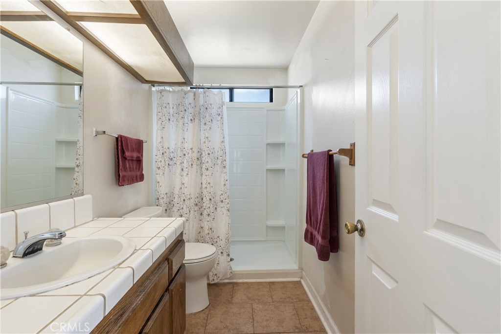 17656 Mockingbird Hill Circle Riverside, CA 92504 - Photo 14 of 49 a bathroom with a granite countertop shower sink vanity and mirror