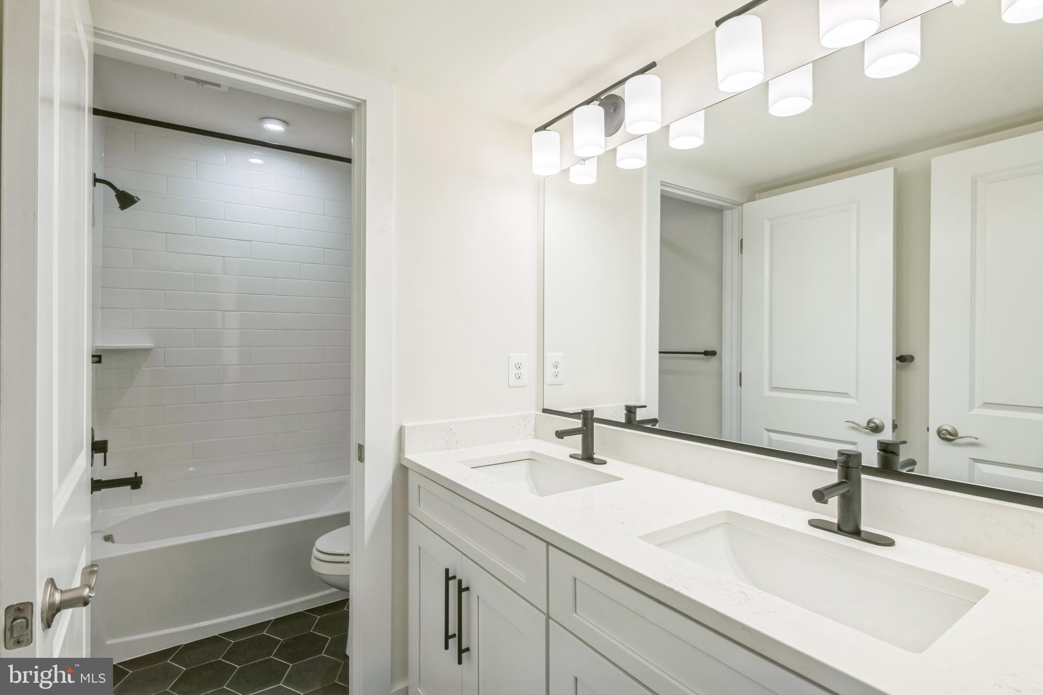 383 Scranton Lane Ocean View, DE 19970 - Photo 10 of 15 a bathroom with a sink a toilet and a large mirror