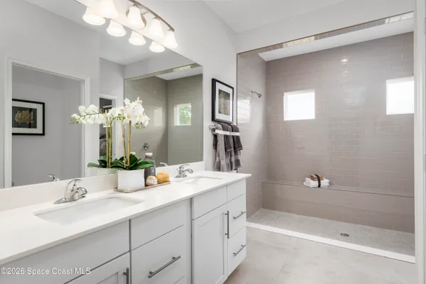 a bathroom with a double vanity sink mirror and shower