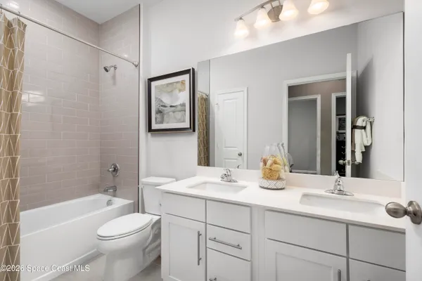 a bathroom with a toilet a sink a tub and mirror