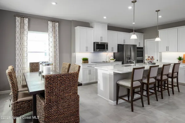 a kitchen with a dining table chairs and microwave