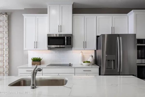 a kitchen with stainless steel appliances kitchen island granite countertop a refrigerator and a stove top oven