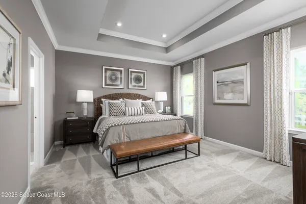 a bed sitting in a bedroom next to a window and a lamp