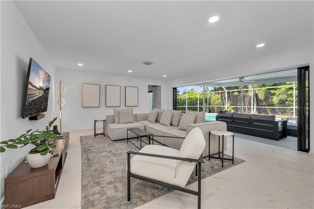 a living room with furniture flat screen tv and a large window