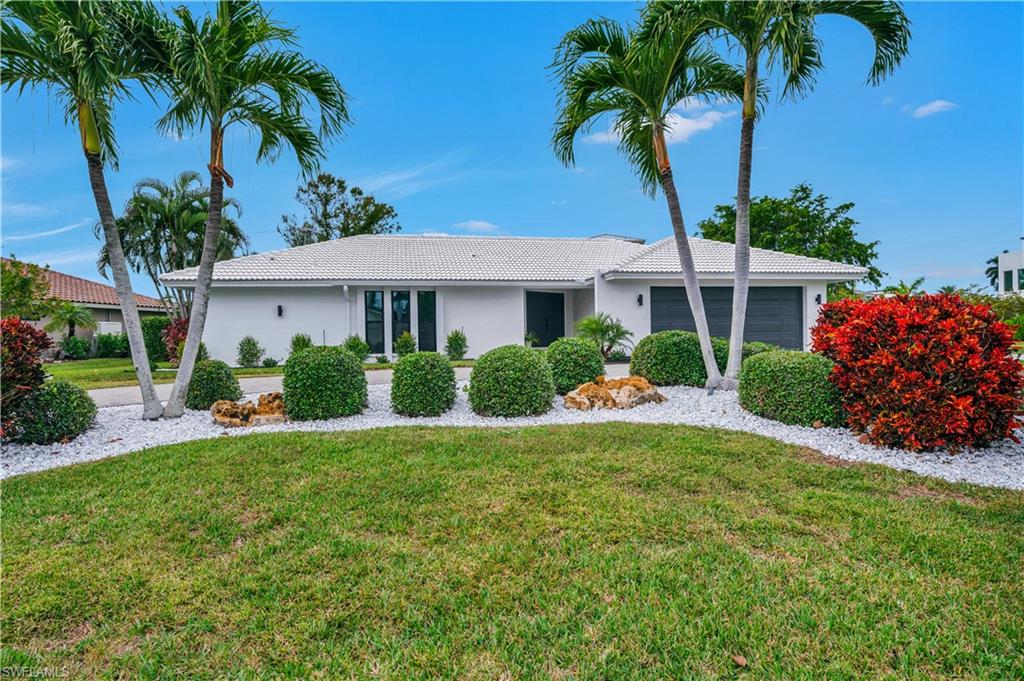 3777 Fountainhead Lane Naples, FL 34103 - Photo 18 of 18 a front view of a house with a garden