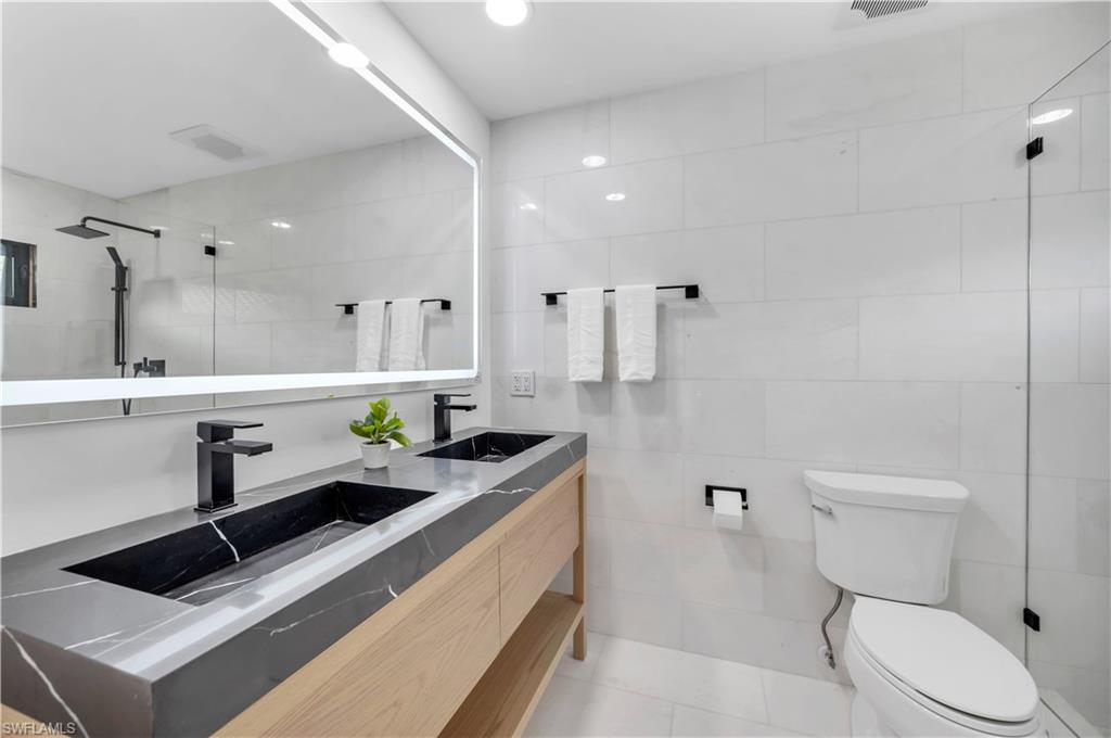 3777 Fountainhead Lane Naples, FL 34103 - Photo 7 of 18 a bathroom with a granite countertop sink mirror vanity and toilet