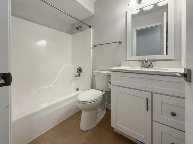 a bathroom with a toilet sink vanity and mirror