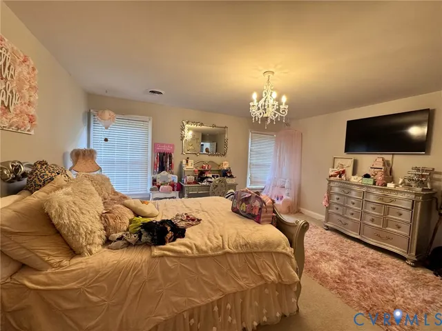a bedroom with bed a flat tv screen and a dresser
