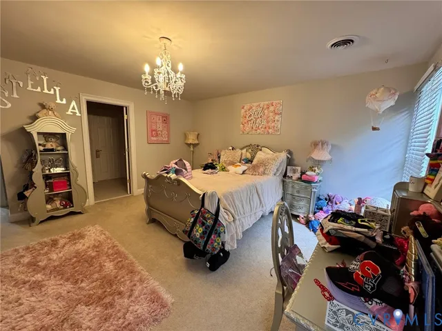 a bedroom with bed and a chandelier