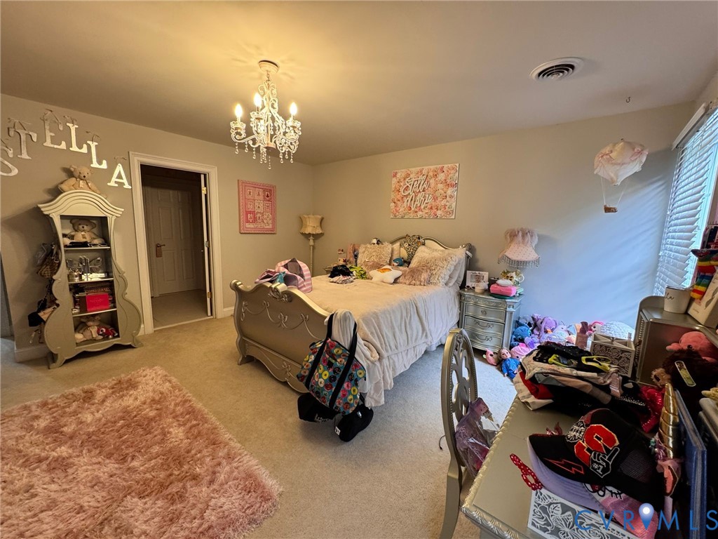 3231 Queens Grant Drive Midlothian, VA 23113 - Photo 28 of 48 a bedroom with bed and a chandelier