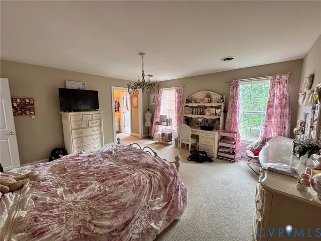 a bed room with a bed a television and dresser