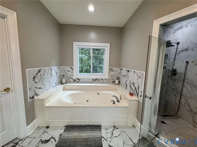 a spacious bathroom with a bathtub and shower