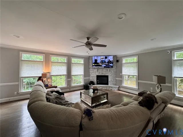 a living room with furniture a large window and a flat screen tv