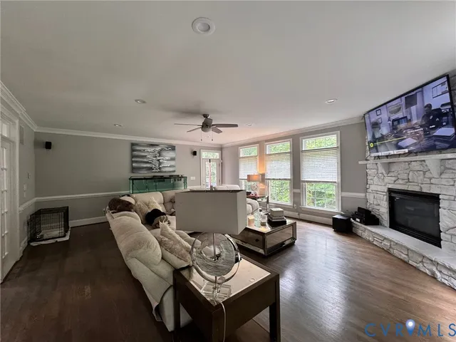 a living room with furniture a fireplace and a floor to ceiling window