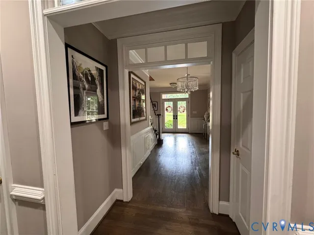 a view of a hallway with wooden floor and a livingroom