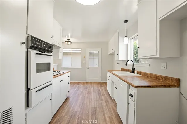 a kitchen with granite countertop a sink stove and refrigerator