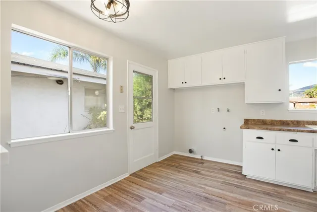 a view of a kitchen with wooden floor and cabinets