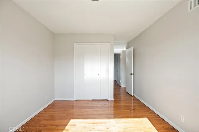 a view of a room that has a window and wooden floor