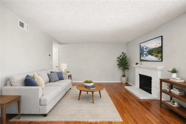 a living room with furniture a fireplace and a potted plant