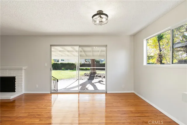 a view of a livingroom with wooden floor and a fireplace