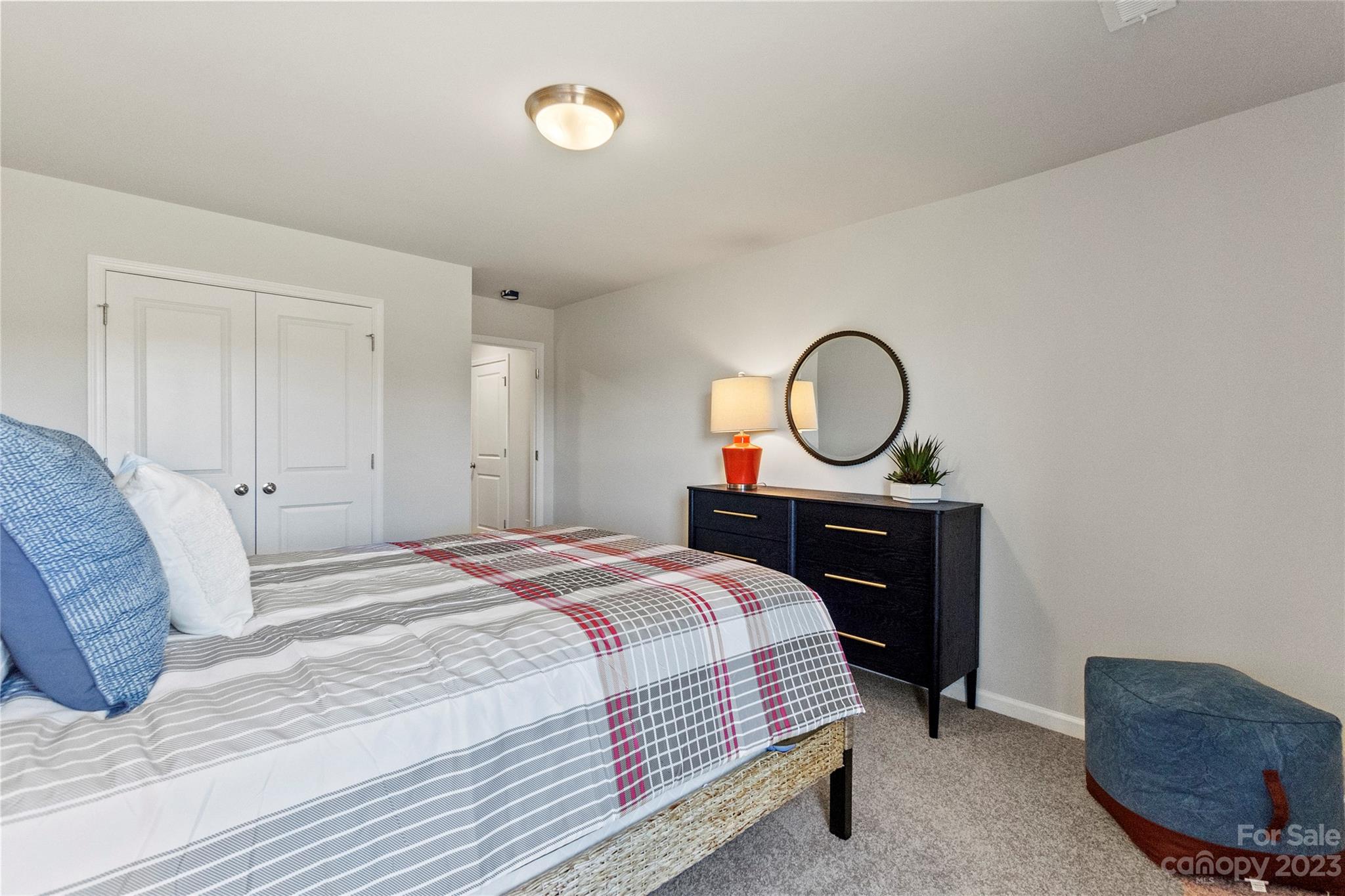 3107 Laurel Brook Drive Denver, NC 28037 - Photo 19 of 31 a bedroom with a bed a mirror and a lamp on dresser