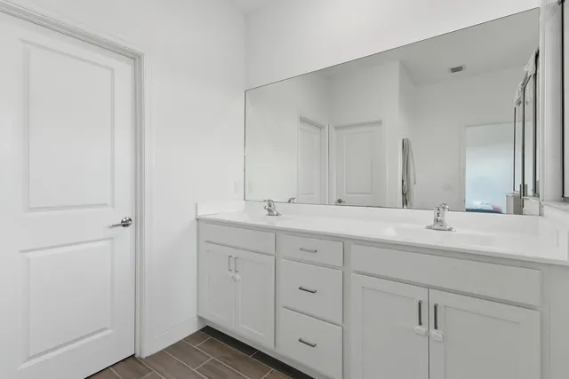 a bathroom with double sink and a mirror