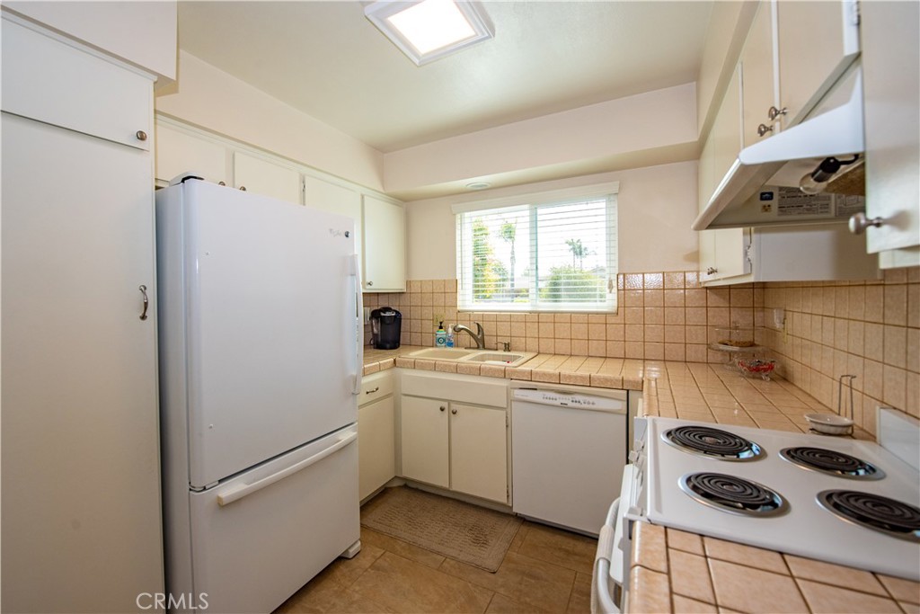 4433 Albatross Way Oceanside, CA 92057 - Photo 23 of 47 a kitchen with a refrigerator a sink and cabinets