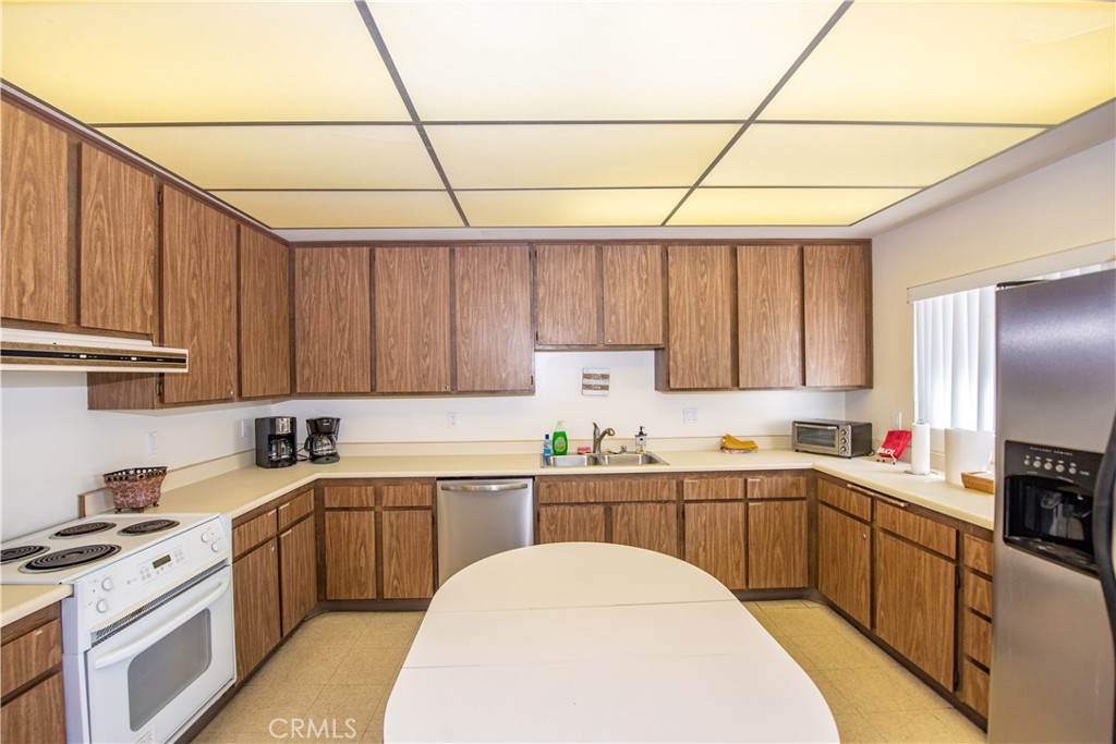 4433 Albatross Way Oceanside, CA 92057 - Photo 46 of 47 a kitchen with stainless steel appliances a sink a stove a refrigerator cabinets and a window